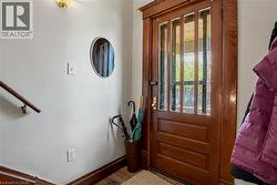 2nd Floor Solid wood entry door with multiple glass lites and dark wood trim - 