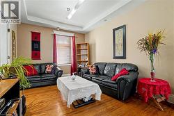 2nd Floor Living area featuring wood-finish flooring, neutral wall paint, and a tray ceiling - 