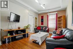 Living area featuring wood-finish flooring, a tray ceiling, - 