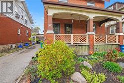 Brick facade featuring a covered front porch with arched details and decorative lattice railing - 