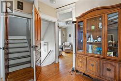 Hardwood flooring with a visible staircase and an open doorway leading to third level - 