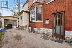 Red brick exterior with a stone foundation, featuring a bay window and a side  entry door - 