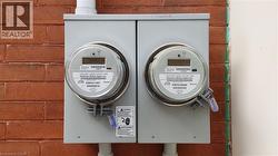Dual utility meters mounted on a brick exterior wall - 