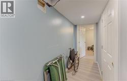 Hallway with light blue walls and wood-finish flooring - 