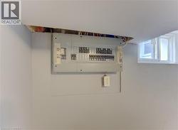 Electrical panel installation with exposed ceiling joists and a basement window - 