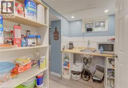 Compact utility area featuring a stainless steel sink, light wood-finish countertop, and white tile backsplash - 