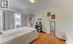 Hardwood flooring, painted walls, window with trim, and a ceiling-mounted light fixture - 
