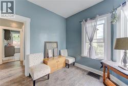 Room featuring blue painted walls, plank-style flooring, white trim, and a white framed window - 