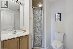Bathroom featuring a light wood-finish vanity with a white countertop and integrated sink, a chrome faucet, and a large wall-mounted mirror - 