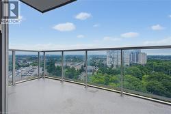 Expansive private balcony featuring a glass railing system and a textured concrete surface - 