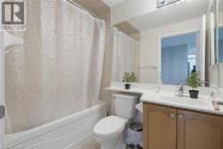 Full bathroom featuring a single vanity, integrated sink, and wood-finish cabinetry - 
