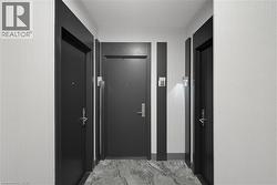 Contemporary corridor featuring three dark paneled doors with matching trim - 