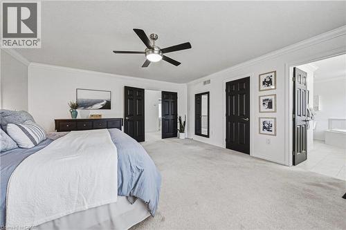 Spacious room featuring light-toned carpet flooring, crown molding, and a ceiling fan with integrated lighting - 20 Degrow Crescent, Binbrook, ON 