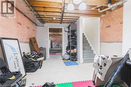 Unfinished lower level with exposed ceiling joists, visible insulation, and concrete flooring - 20 Degrow Crescent, Binbrook, ON 