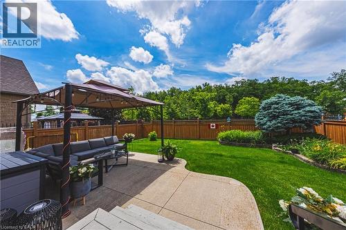 Expansive backyard featuring a concrete patio with a permanent gazebo structure - 20 Degrow Crescent, Binbrook, ON 