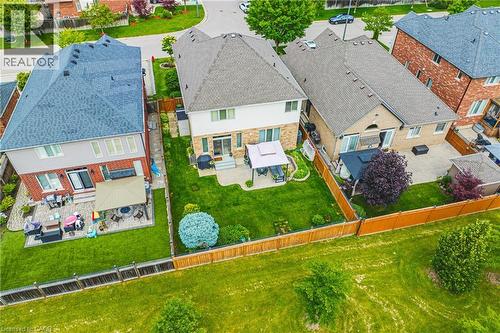 Expansive backyard featuring a manicured lawn, paved patio, and mature landscaping - 20 Degrow Crescent, Binbrook, ON 