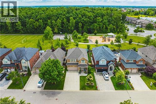 Neighborhood featuring single-family residences, a large green space, a playground, and mature trees - 20 Degrow Crescent, Binbrook, ON 