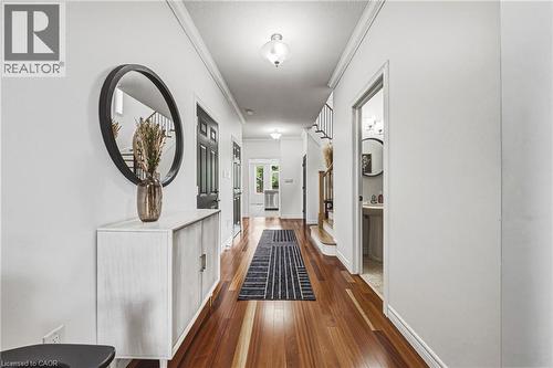 Spacious hallway featuring polished wood flooring and white walls - 20 Degrow Crescent, Binbrook, ON 
