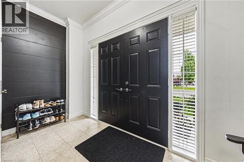 Double entry doors with paneled detailing, complemented by two sidelight windows with horizontal blinds - 20 Degrow Crescent, Binbrook, ON 