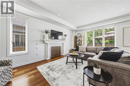 Bright living space featuring warm wood-finish flooring, recessed lighting, and crown molding - 20 Degrow Crescent, Binbrook, ON 