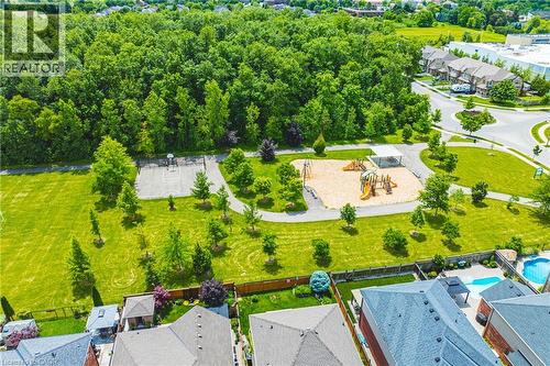 Community park area featuring a sand play structure, covered picnic space, and a paved sports court - 20 Degrow Crescent, Binbrook, ON 