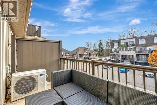 Outdoor balcony featuring a privacy wall, durable railing, and a clear sky backdrop - 236 Rachel Crescent Unit# E, Kitchener, ON 