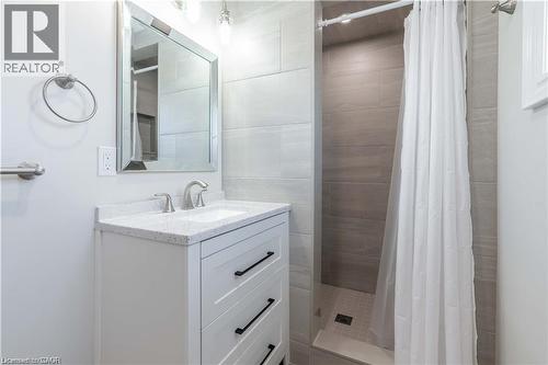 Bathroom featuring a white vanity with a speckled countertop, undermount sink, and brushed nickel faucet - 66 Queen Street W, Cambridge, ON 