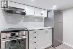 Stainless steel appliances, including a range and refrigerator, complement the white shaker-style cabinetry - 