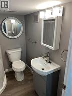Compact bathroom featuring a white toilet, contemporary wall vanity, and white basin with a single-handle faucet - 