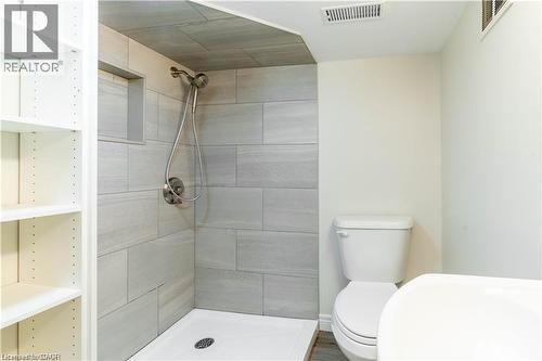 Walk-in shower featuring light grey tile surround, recessed niche, and a brushed nickel shower head - 66 Queen Street W, Cambridge, ON 
