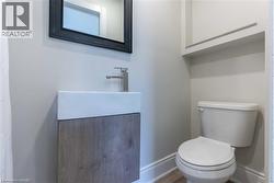 Modern powder room featuring a wall-mounted vanity with integrated sink, contemporary chrome faucet, and a framed mirror - 