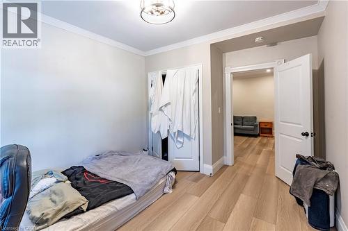 Interior room with wood-finish flooring, white trim, and a ceiling-mounted light fixture - 66 Queen Street W, Cambridge, ON 