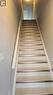 Staircase featuring light-toned tile treads with metal nosing and a painted handrail - 42 Wheat Lane Unit# 42, Kitchener, ON 