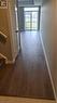 Wood-finish flooring extending to a sliding glass door with a balcony, presenting a view of exterior residences - 42 Wheat Lane Unit# 42, Kitchener, ON 
