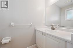 Bathroom featuring a white vanity with panel cabinetry, an integrated white sink, and a brushed nickel faucet - 