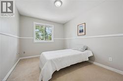 Room featuring light gray walls with chair rail molding, a single pane window, and neutral-toned carpeting - 