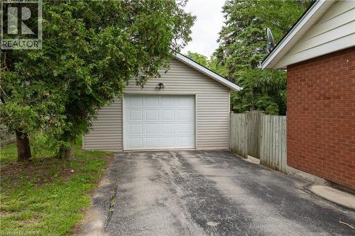 Spacious garage with exposed wood framing, concrete flooring, and overhead lighting - 156 Mutual Street N, Ingersoll, ON 