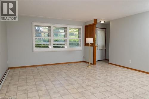 Spacious interior room featuring light-toned flooring, expansive windows with horizontal blinds, and a neutral wall color - 156 Mutual Street N, Ingersoll, ON 