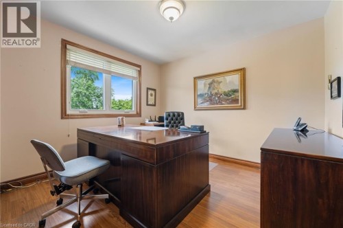 Room featuring wood-finish flooring, a window with horizontal blinds, and neutral-toned walls - 7 Thomson Road, Simcoe, ON 