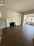 Living area featuring wood-finish flooring, a tiled fireplace surround, and multiple windows - 947 Main Street E, Hamilton, ON  - Indoor Photo Showing Other Room 