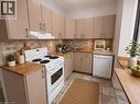 Kitchen featuring wood-finish countertops, neutral cabinetry, a tile backsplash, and a ceramic tile floor - 947 Main Street E, Hamilton, ON  - Indoor Photo Showing Kitchen 