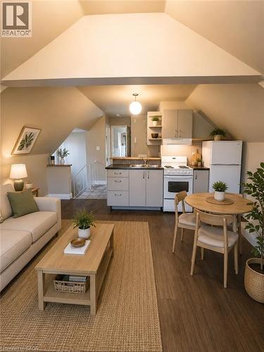 Open-concept living space featuring wood-finish flooring, a kitchen with light cabinetry, a white refrigerator, and a built-in range - 947 Main Street E, Hamilton, ON - Indoor Photo Showing Living Room