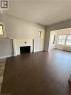 Living area featuring wood-finish flooring, a tiled fireplace surround, and multiple windows - 947 Main Street E, Hamilton, ON 