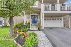 Exterior featuring a blue double-door entry, a covered porch, and an attached garage with a paved driveway - 