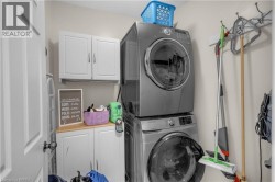 Dedicated laundry area featuring stacked front-load machines - 