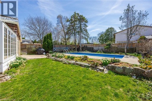 Expansive backyard featuring a rectangular swimming pool, concrete patio, green lawn, and established perimeter fencing - 277 Blackacres Boulevard, London, ON 