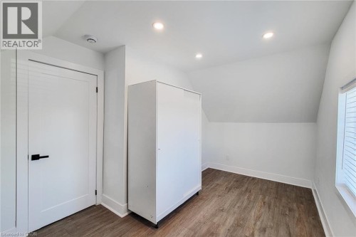 Room featuring a sloped ceiling, wood-finish flooring, recessed lighting, and a window with blinds - 78 Hillyard Street, Hamilton, ON 