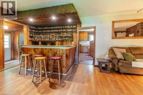 Wood-paneled bar area with recessed lighting, integrated shelving, and wood-finish flooring - 382 Beach Boulevard, Hamilton, ON 