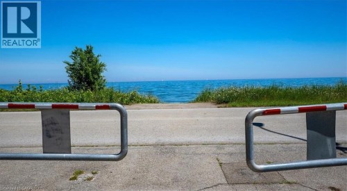 Waterfront access with natural shoreline, mature trees, and clear blue skies - 382 Beach Boulevard, Hamilton, ON 