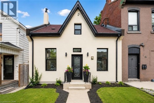 Stucco exterior with a peaked roofline and black trim accents - 118 Cathcart Street, Hamilton, ON 
